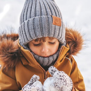 chłopak w musztardowej kurtce zimowej i zestawie czapka i komin z wełny merino