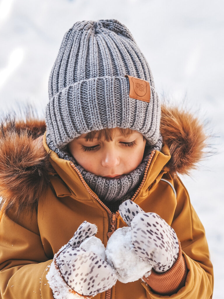 chłopak w musztardowej kurtce zimowej i zestawie czapka i komin z wełny merino