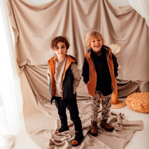 stylizacja dla chłopca: beżowa bluza w misie z czarną kamizelką i czarne spodnie dla chłopca oraz czarna bluza dzięcięca i wzorzyste spodnie dla chłopca